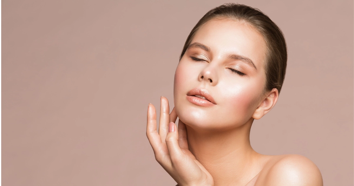 A young woman with glowing skin touching her neck after a CoolPeel treatment in San Antonio, TX